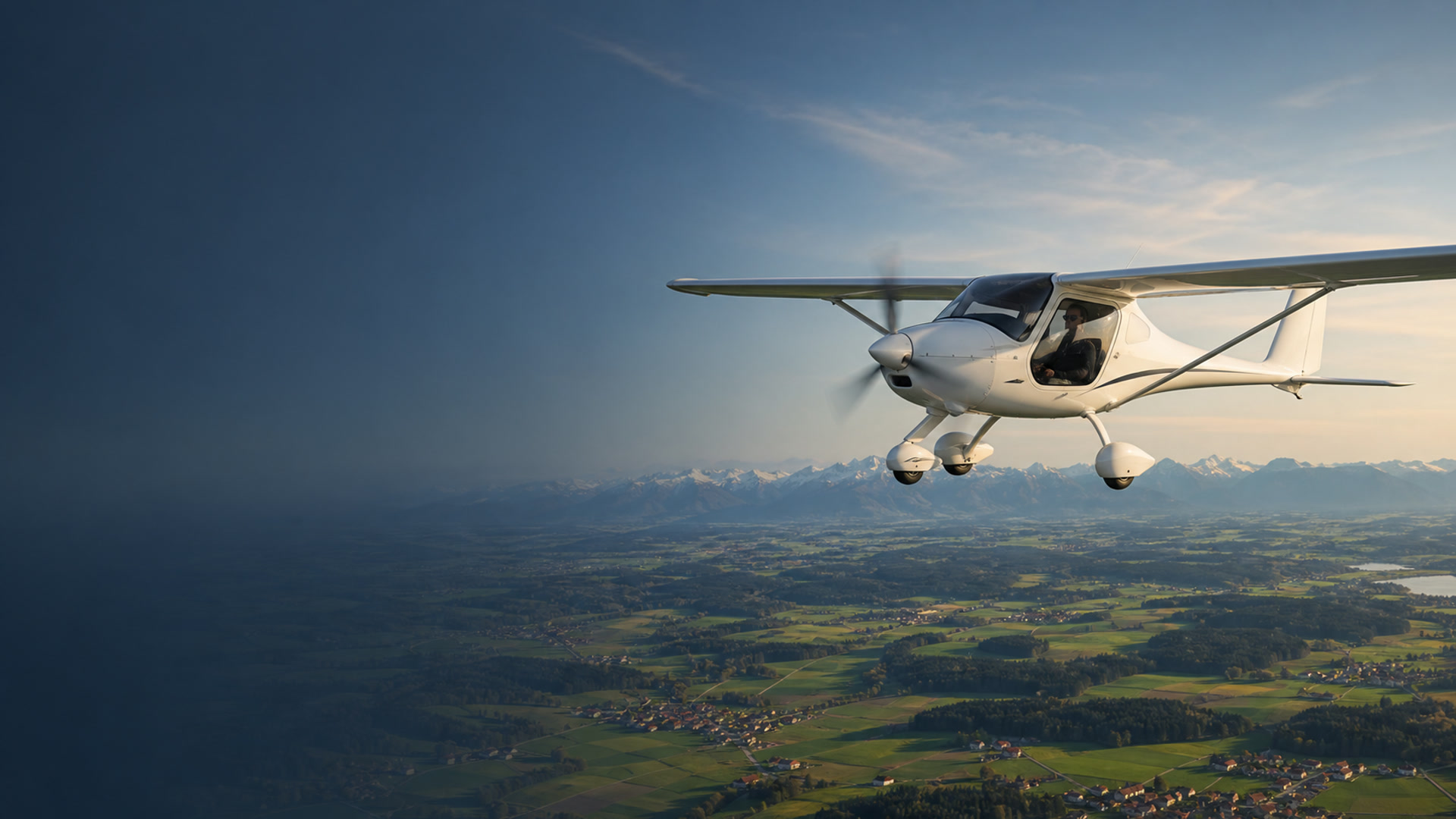 Ultraleichtflugzeug im Flug über der bayerischen Voralpenlandschaft bei tief stehender Sonne